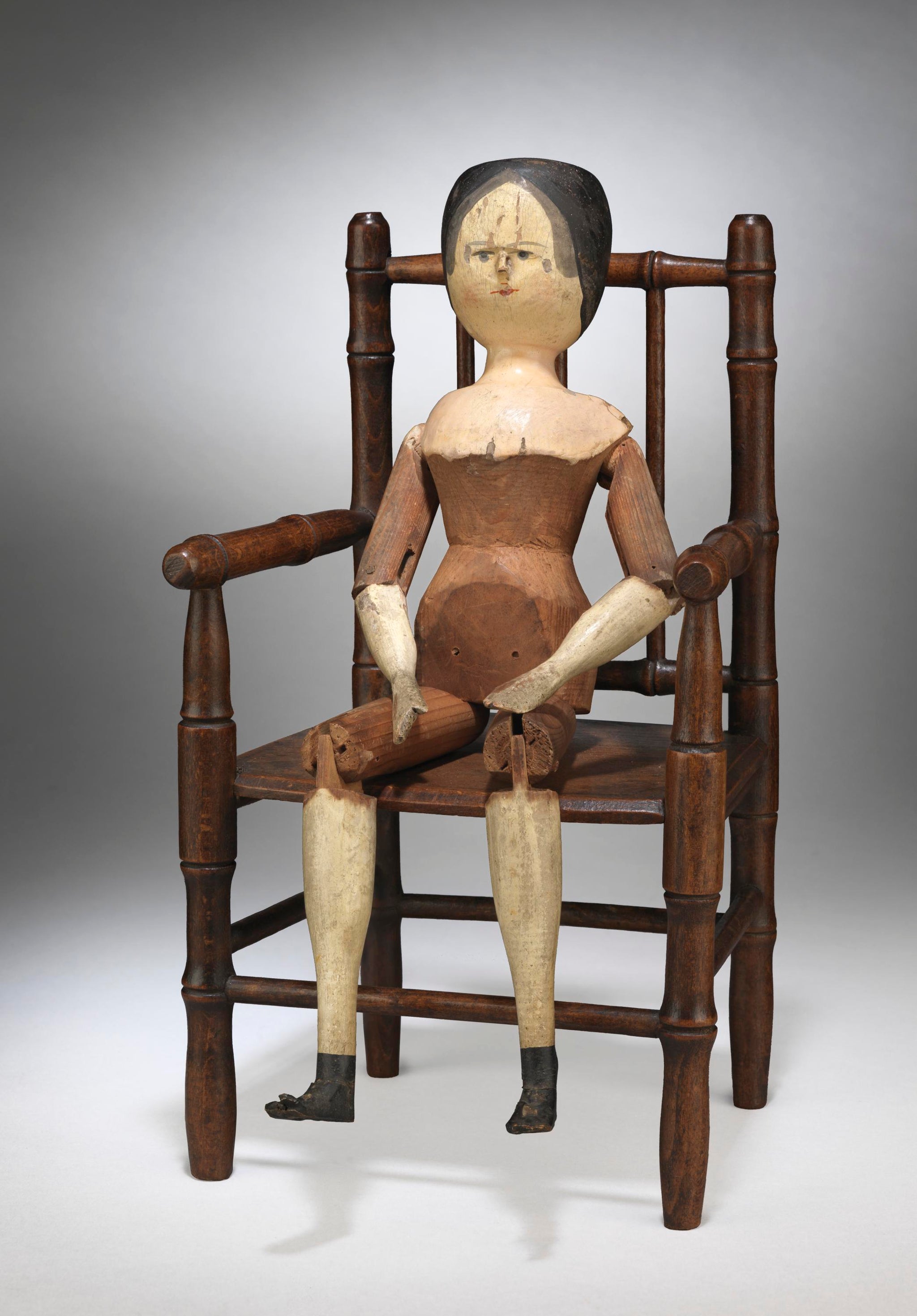 Traditional Primitive Peg Doll Seated in a Miniature Simulated Bamboo Armchair