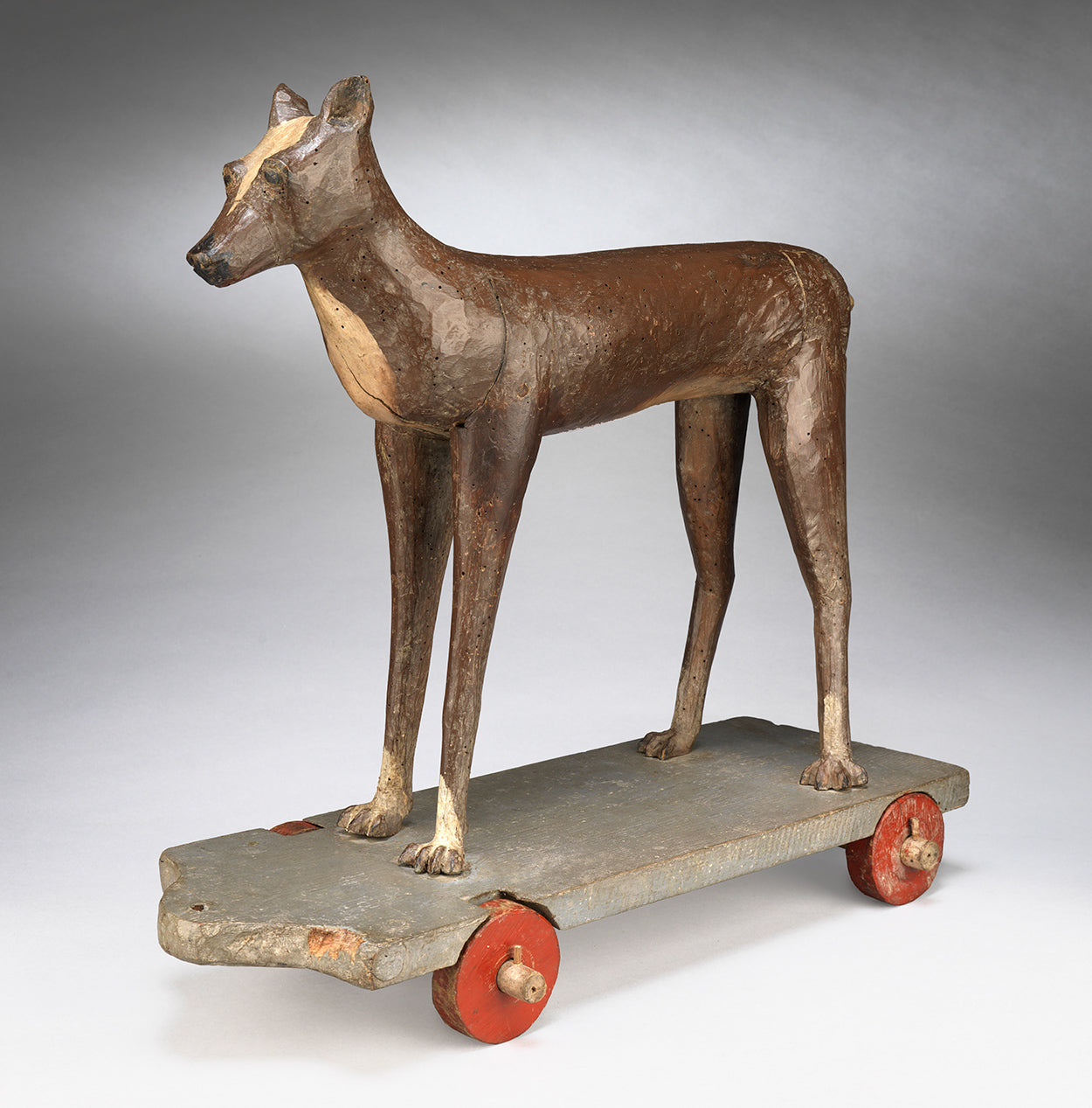An Extraordinary Stylised Primitive Carving of a Hound